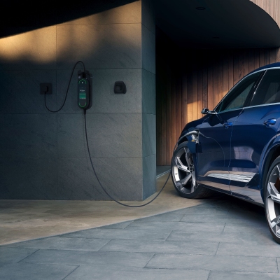 Audi e-tron 55 electric SUV is plugged into a charging station
